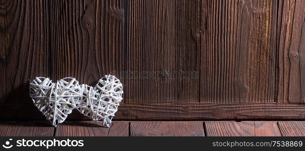 Two wicker hearts on wooden background with copy space for text. Two wicker hearts