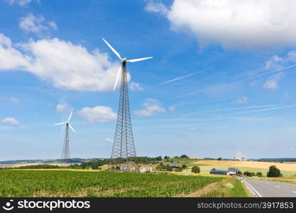 Two windmills in countryside with blue sky and white clouds in Germany