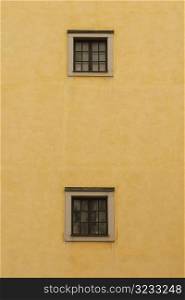 Two windows on yellow brick wall