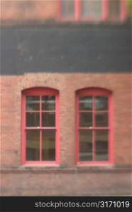 Two Windows With Red Trim in Brick Building