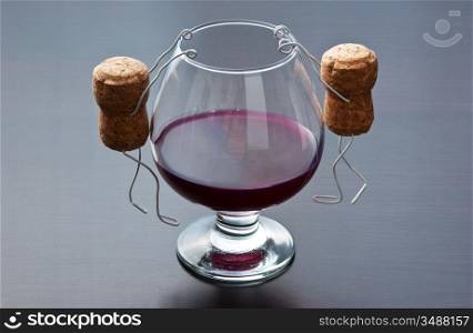 two wine cork are hanging on a glass of wine