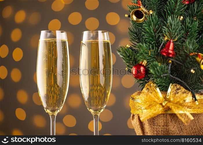 Two wine glasses with bubbly champagne and Christmas tree with decor on background of blurry sparkling lights. Happy New Year holiday greeting card, banner, header with copy space 