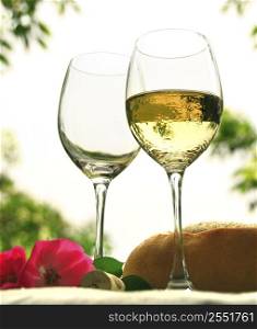 Two wineglasses with white wine on the table outside