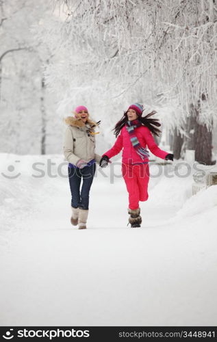 two winter women run by snow frosted alley