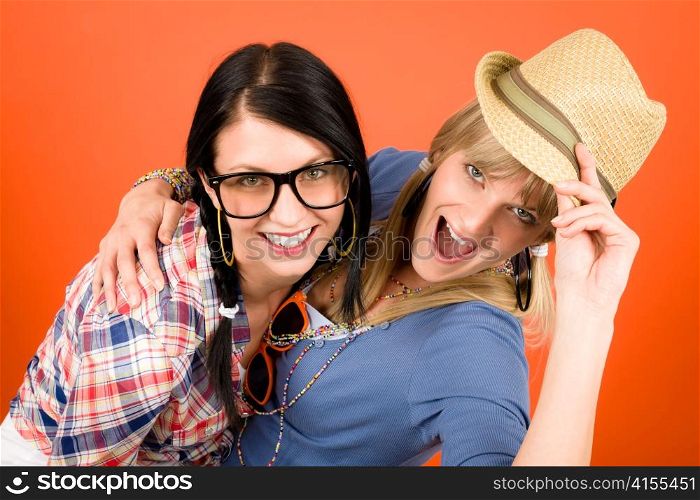 Two woman friends young have fun crazy smiling orange background