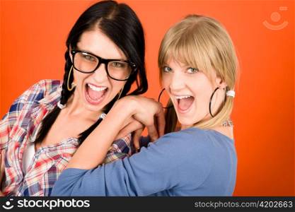 Two woman friends young have fun crazy smiling orange background