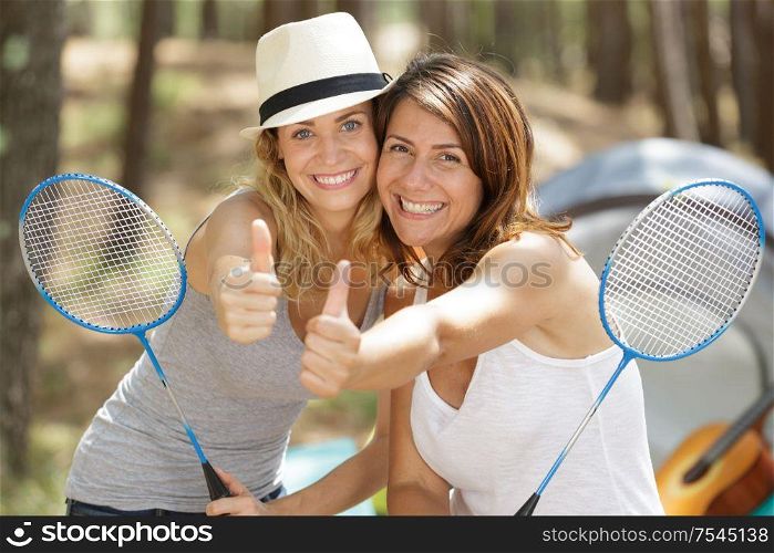 two woman playing badminton outdoors