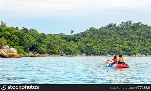 Two woman tourists are mother and daughter. Travel by boat with a kayak happy on the sea in the morning of summer at Ko Lipe island is the background, Tarutao National Park, Satun, Thailand. Two woman travel by kayak at Ko Lipe island, Thailand