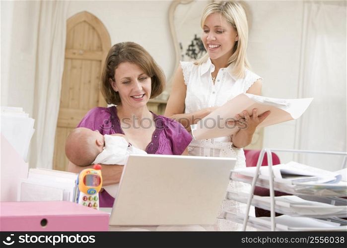 Two women and a baby in home office with laptop
