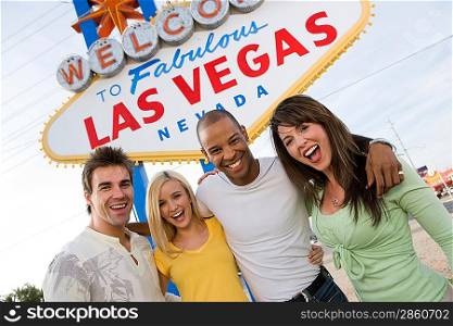 Two women and two men in front of Welcome to Las Vegas sign, group portrait