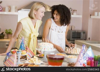 Two women at party getting sandwiches smiling