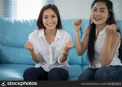 two women Competitive friends excited happy cheerful and smiling at home