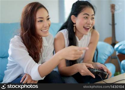 two women Competitive friends playing video games and excited happy cheerful at home