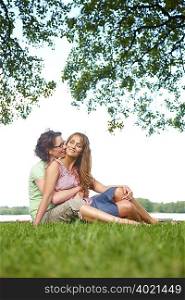 Two women cuddling in park