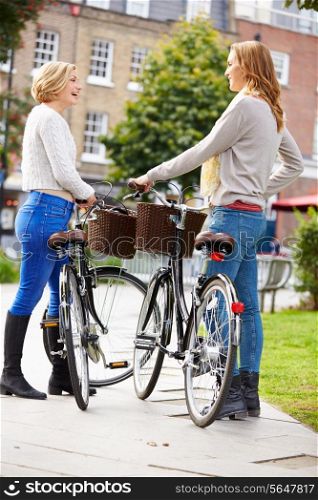 Two Women Cycling Through Urban Park Together