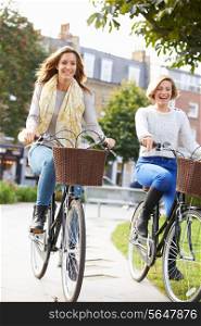 Two Women Cycling Through Urban Park Together