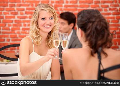 Two women drinking champagne in restaurant