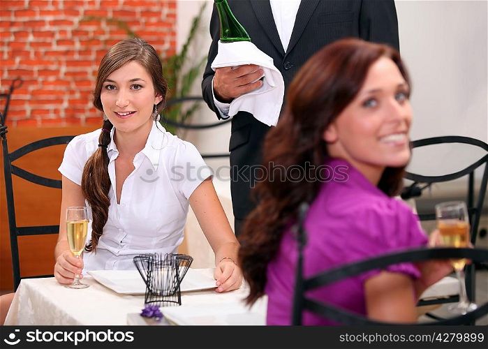 two women drinking sparkling wine at restaurant