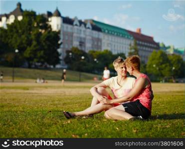 Two women embracing in the park in the afternoon sunlight, city park
