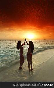 Two women enjoying sunset on beach