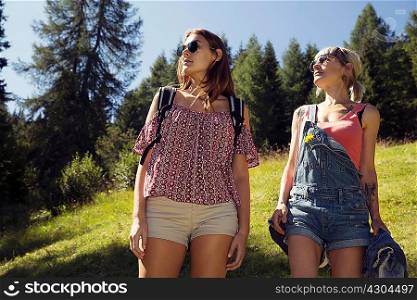 Two women gazing from forest glade, Sattelbergalm, Tyrol, Austria