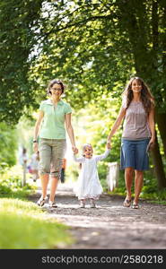 Two women holding girls hands