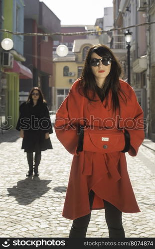 Two women in jackets on a street. Sunlight