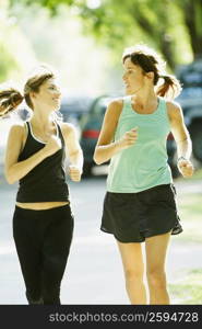 Two women jogging on the road
