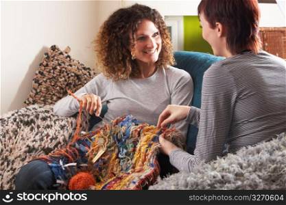Two Women Knitting Together At Home