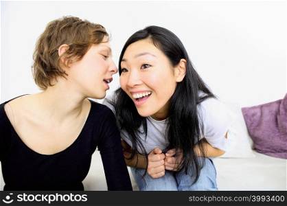 Two women laughing on sofa