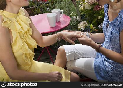 two women looking at hands