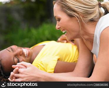 Two women lying down and laughing side view