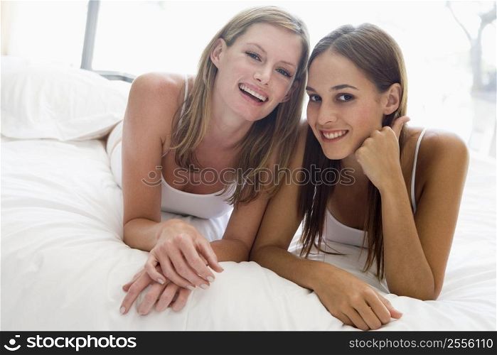 Two women lying in bed smiling