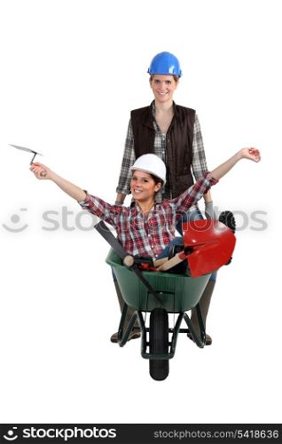 Two women messing around with wheelbarrow
