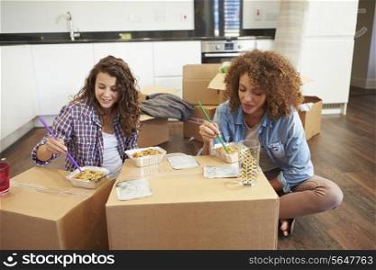 Two Women Moving Into New Home Enjoying Takeaway Meal