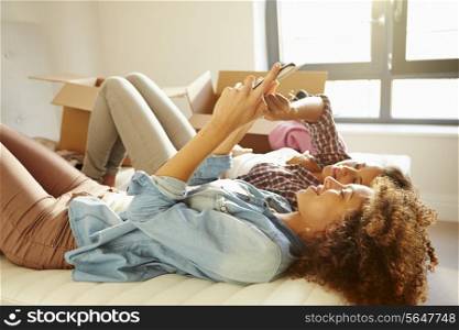 Two Women Moving Into New Home Using Digital Tablet