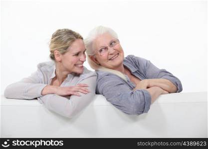 Two women on a white sofa