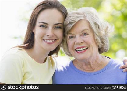 Two women outdoors embracing and smiling