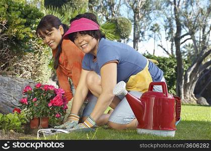 Two women planting flowers in garden