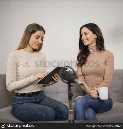 two women radio studio with microphone tablet