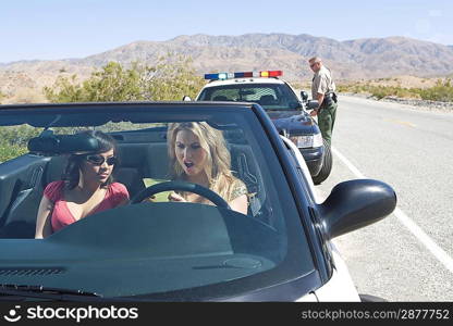 Two women reading speeding ticket in car