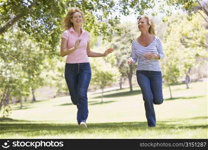 Two women running in park and smiling