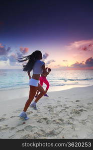 Two women running on beach