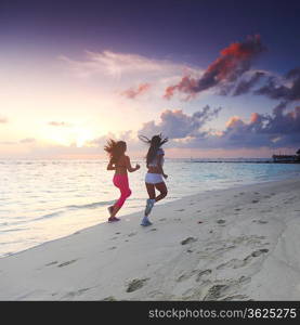 Two women running on beach