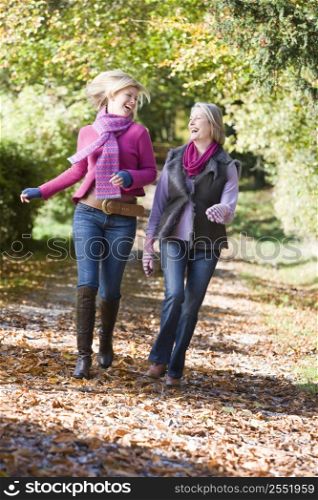 Two women running outdoors in park and smiling