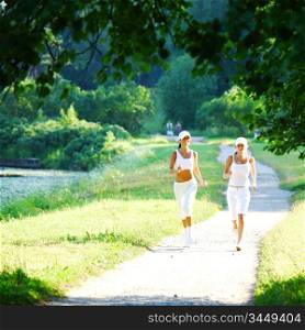 Two women running through a park