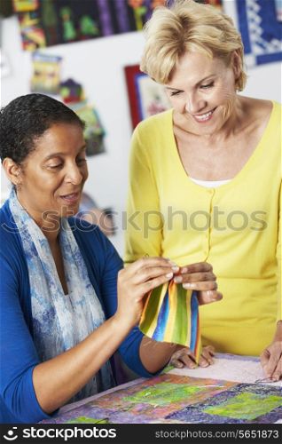 Two Women Sewing Quilt Together