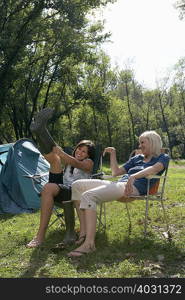 Two women sitting at campsite laughing