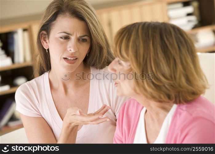 Two women sitting in living room arguing
