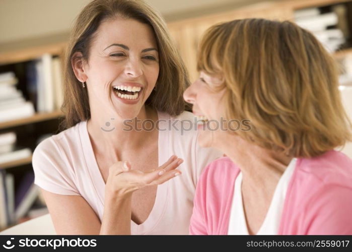 Two women sitting in living room talking and laughing